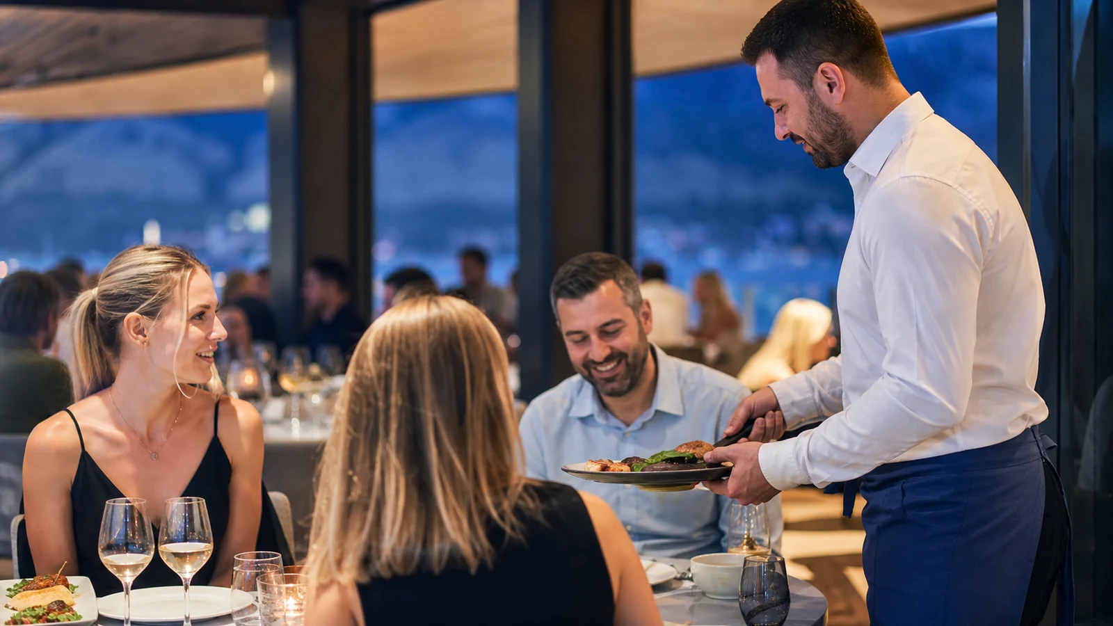 Konobar poslužuje goste u restoranu tokom servisa